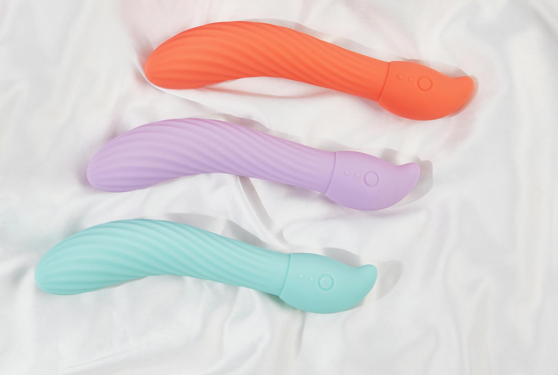 A couple standing together indoors, holding a vibrator and smiling, symbolizing shared intimacy and modern connection