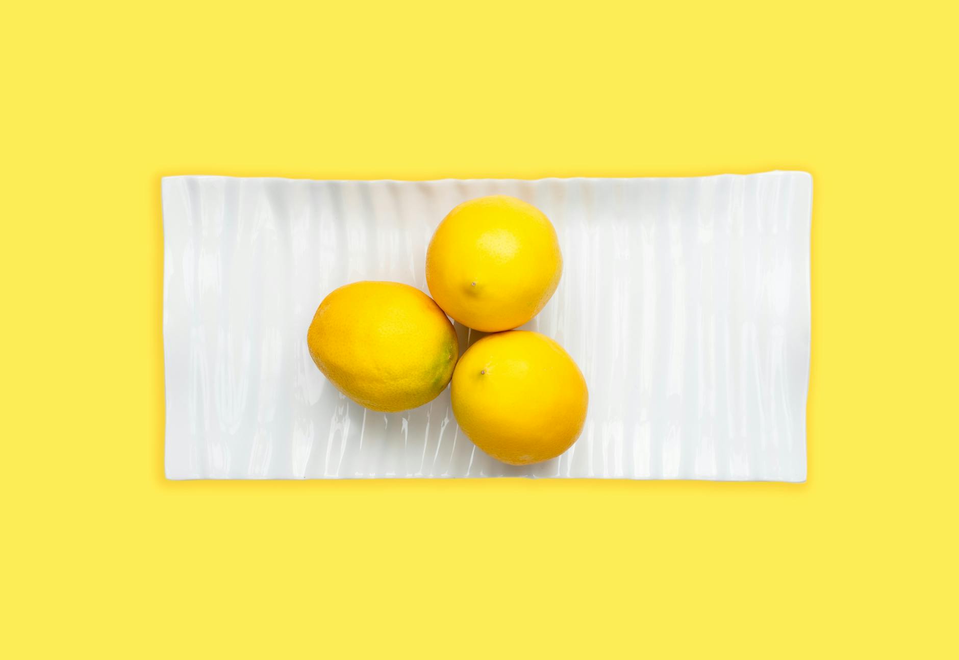 Vibrador de limão amarelo em fundo minimalista, simbolizando prazer e bem-estar sexual.