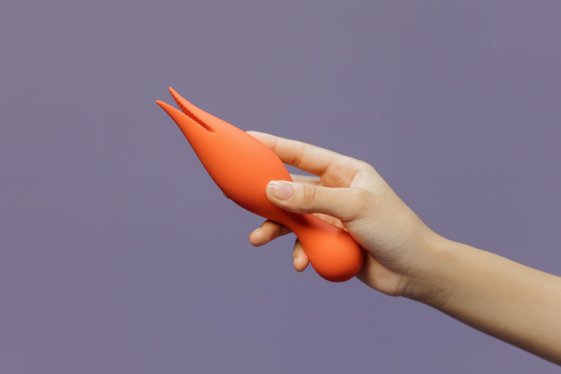 A yellow silicone lemon clitoral vibrator surrounded by peeled bananas on a yellow background