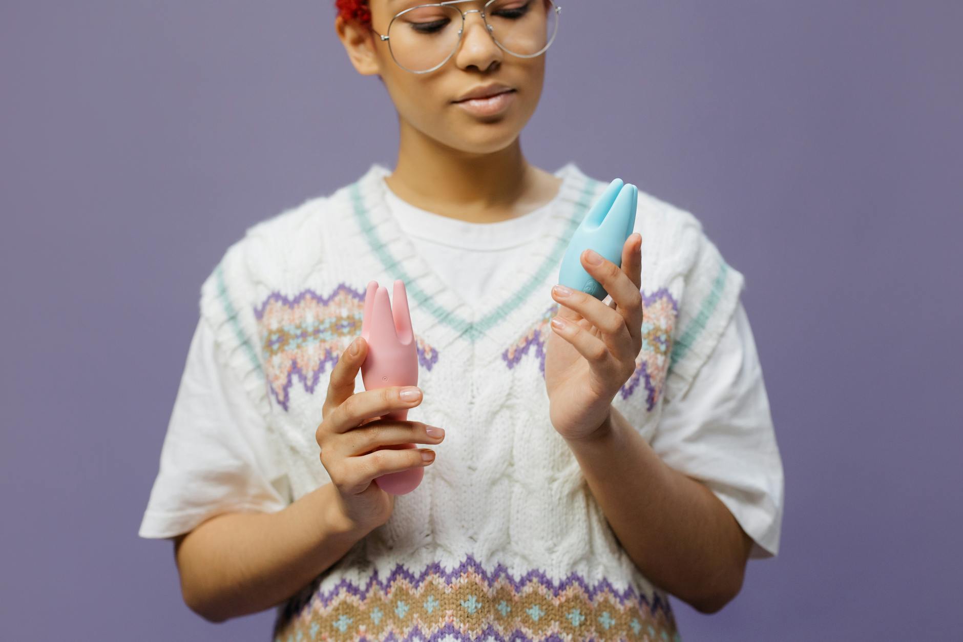 Mulher com óculos segurando vibradores de silicone em tom contemplativo durante recuperação.
